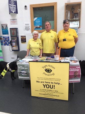 Photo showing Maureen and Mike Blake (Secretary and Chair) with Sandra Steadman (Trustee) standing behind a stall at an event.